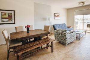 a living room with a wooden table and a couch at Cabo Cottage Bahia del Tezal in Cabo San Lucas