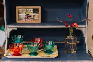a shelf with different colored cups and a vase with flowers at Art Gallery Residence in Braşov