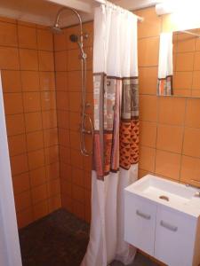 a bathroom with a shower curtain and a sink at Kaz Luciole in Deshaies