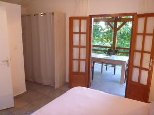 Zimmer mit einem Bett, einem Tisch und einem Fenster in der Unterkunft Kaz Luciole in Deshaies
