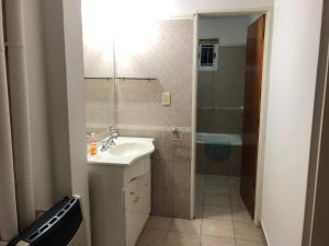 ein Badezimmer mit Waschbecken und Dusche in der Unterkunft Saint Michel Departamentos para turismo in Alta Gracia