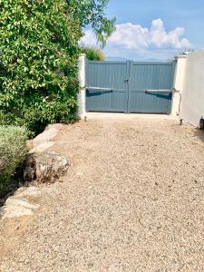 una cerca azul con una puerta en un patio en Villa CASAMIRAFIO à PALOMBAGGIA piscine chauffée et 8 à 9 personnes, en Porto Vecchio