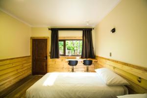 a bedroom with two beds and a window at Kalfu Patagonia in Cochrane