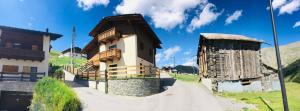 een huis met een houten dak op een onverharde weg bij Chalet Clida in Livigno