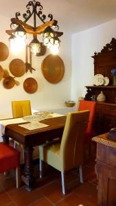 una sala da pranzo con tavolo, sedie e piatti appesi al muro di Su Carreri ad Armungia