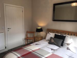 ein Schlafzimmer mit einem Bett, einem Stuhl und einem Spiegel in der Unterkunft Haddington George House in Edinburgh