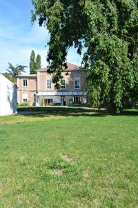 une grande cour avec une maison et un arbre dans l'établissement La KEFOISE, à Fouquières-lès-Lens