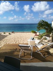 dwa krzesła i stół na plaży w obiekcie Bleu Marine Beach w mieście Grand Case