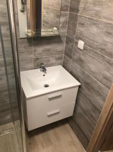 a bathroom with a white sink and a mirror at Flat in the Heart of Liptovsky Mikulas in Liptovský Mikuláš