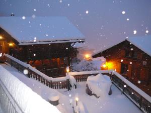 una casa cubierta de nieve por la noche con luces en Chalet Rayon de Soleil, en Gryon