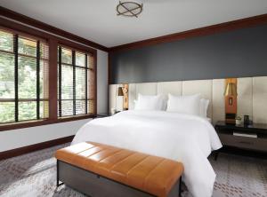 a bedroom with a large white bed and windows at Four Seasons Resort Whistler in Whistler