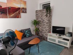 a living room with a couch and a tv at Casa da açoteia in Olhão