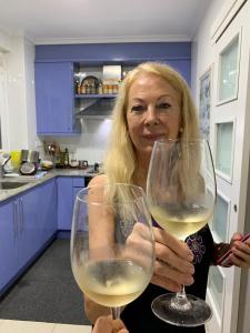 a woman holding two glasses of white wine at Habitación privada a 1500 metros de la playa in Valencia
