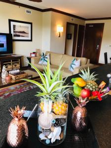 una sala de estar con una mesa con fruta en jarrones en Beach Villa at Ko'Olina, en Kapolei