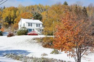 ein weißes Haus im Schnee mit Bäumen in der Unterkunft Hawes Home in Antigonish