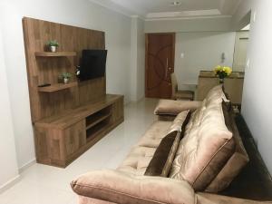 un salon avec deux canapés bruns et une télévision dans l'établissement MARAVILHOSO apartamento QUADRA MAR em BC, à Balneário Camboriú