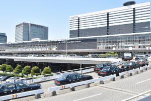 a parking lot with cars parked in front of a building at Enzo Shin-Osaka C in Osaka