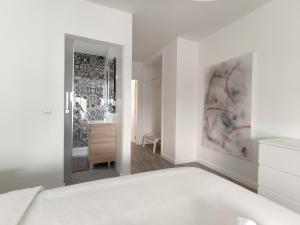 a white bedroom with a bed and a bathroom at Apartments City Center • Collection by Perpetual Relax in Braga