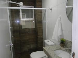a bathroom with a shower and a toilet and a sink at Ed forte da Praia in Guarapari +9 photos