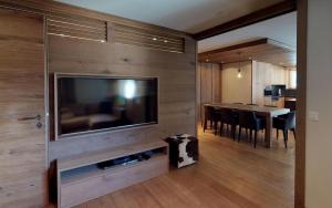 een woonkamer met een televisie en een eetkamer bij Ruinatsch 67 in St. Moritz