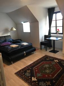 a bedroom with a bed and a table and a rug at HotelPandekagehuset B&B in Nykøbing Sjælland