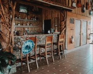 a bar in a log cabin with wooden chairs at Casa de Olas Boutique Hotel in Puerto Escondido