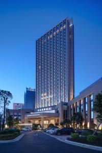 a large building with a parking lot in front of it at Dongguan Dongcheng International Hotel - Dongcheng Bar Street in Dongguan