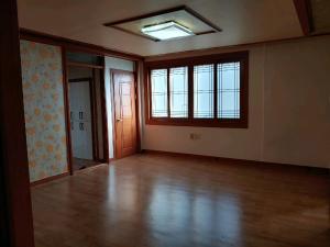 an empty room with wooden floors and a window at Gimhae Guest House in Gimhae