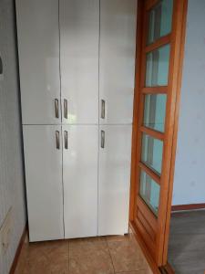 Zimmer mit weißen Schränken neben einer Tür in der Unterkunft Gimhae Guest House in Gimhae
