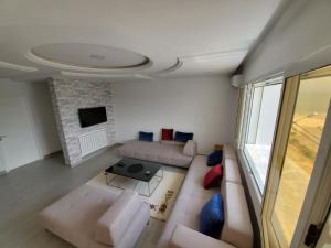 a living room with a couch and a tv at Altavista Appartment in Sousse