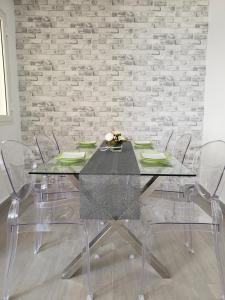 uma mesa de jantar com 4 cadeiras e uma parede de tijolos em Altavista Appartment em Sousse