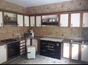 a kitchen with black and white cabinets and a microwave at Casa de Campo en Sardiñeiro de Arriba in Finisterre