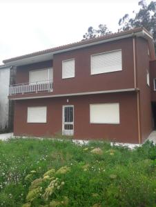 a red house with white windows and a yard at Casa de Campo en Sardiñeiro de Arriba in Finisterre