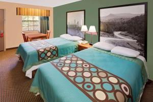 a hotel room with two beds and a desk at Super 8 by Wyndham Hazen in Hazen +22 photos