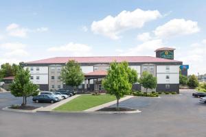 a hotel with cars parked in a parking lot at La Quinta by Wyndham Blue Springs in Blue Springs