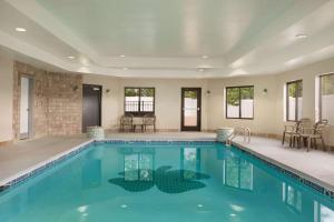 a swimming pool with chairs and tables in a building at La Quinta by Wyndham Dublin in Dublin