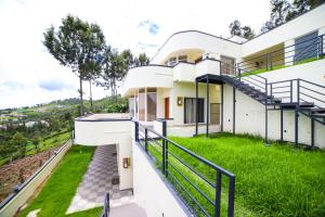 a house with a green lawn and stairs at Aira Residency Kothagiri by Lexstays in Kotagiri