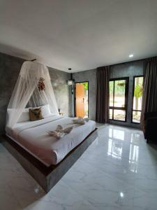 a bedroom with a large bed with a mosquito net at Phumaihom Resort in Hat Yai