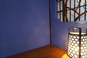 a lamp in a room with a blue wall at 小さなお宿 乃むら in Kanazawa