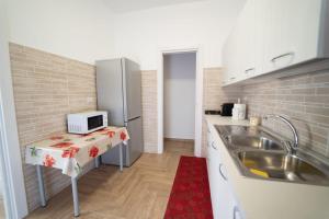 una pequeña cocina con fregadero y nevera. en Appartamento Campanella, en Isola di Capo Rizzuto