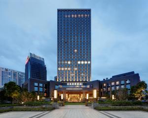 un edificio alto con una plaza delante en Dongguan Dongcheng International Hotel - Dongcheng Bar Street, en Dongguan