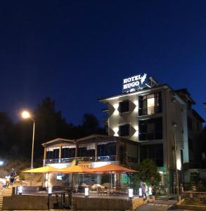 ein Gebäude mit Sonnenschirmen in der Nacht davor in der Unterkunft Hotel Hugo in Altınoluk