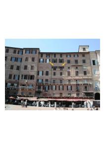 un grande edificio con due aquiloni che volano davanti di I Balconcini a Siena