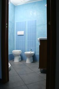 Baño de azulejos azules con aseo y lavamanos en Villa Carmela, en Sessa Aurunca