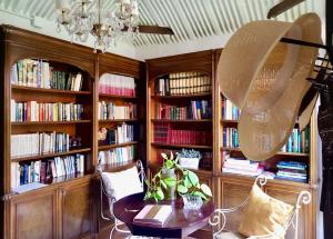 a library with wooden book shelves filled with books at Emblemática Los Helechos in Los Realejos