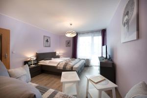 een slaapkamer met 2 bedden en een woonkamer bij B2B Apartments in Jihlava