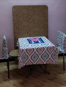 einen Tisch und zwei Stühle in einem Zimmer in der Unterkunft Atreyaa Homestay in Tiruchchirāppalli