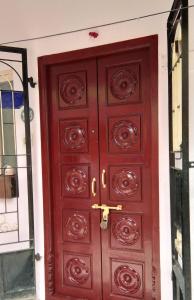 eine große Holztür mit einem goldenen Knopf drauf in der Unterkunft Atreyaa Homestay in Tiruchchirāppalli