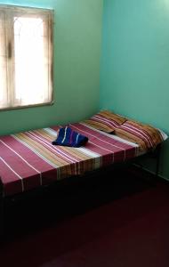 Bett in einem Zimmer mit Fenster in der Unterkunft Atreyaa Homestay in Tiruchchirāppalli