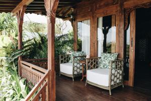 un porche con 2 sillas y plantas en White Tortoise Eco Villa's, en Uluwatu